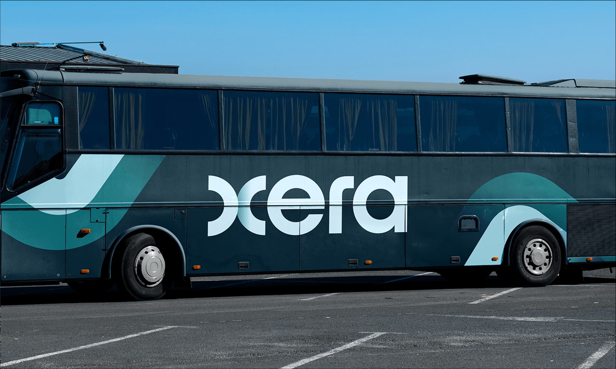 Black and teal bus featuring the logo "xcera" parked in a lot. Modern design with large windows.